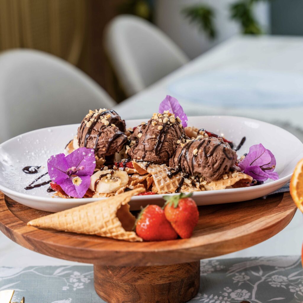 NUTELLA CRUSHED WAFFLE NACHOS Crushed waffle pieces topped with fresh strawberries & bananas, Nutella ice cream, peanuts, chocolate drizzle & whipped cream.